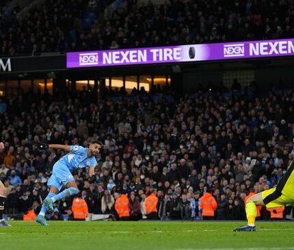 MANCHESTER, ENGLAND - MARCH 06: Riyad Mahrez of Manchester City scores their sides fourth goal pas David De Gea of Manchester United during the Premier League match between Manchester City and Manchester United at Etihad Stadium on March 06, 2022 in Manchester, England. (Photo by Matt McNulty - Manchester City/Manchester City FC via Getty Images)